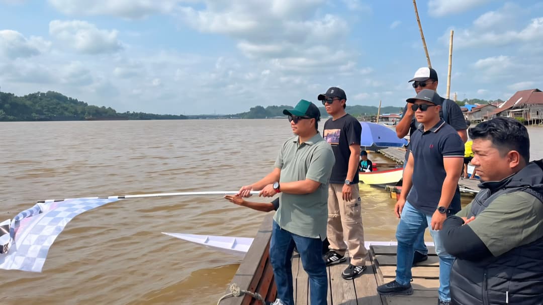 Sekretaris Camat Loa Kulu, Khairuddinata mengibarkan bendera tanda perlombaan dimulai.